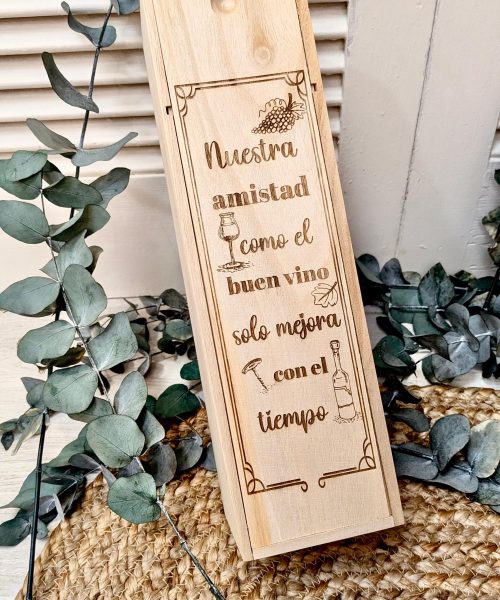Caja de madera con un grabado que dice 'Nuestra amistad como el buen vino solo mejora con el tiempo'.